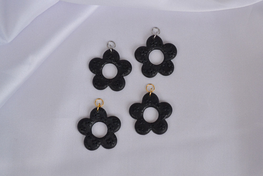 Obenansicht von viert schwarzen Blumen mit Blumenmuster für Creolen