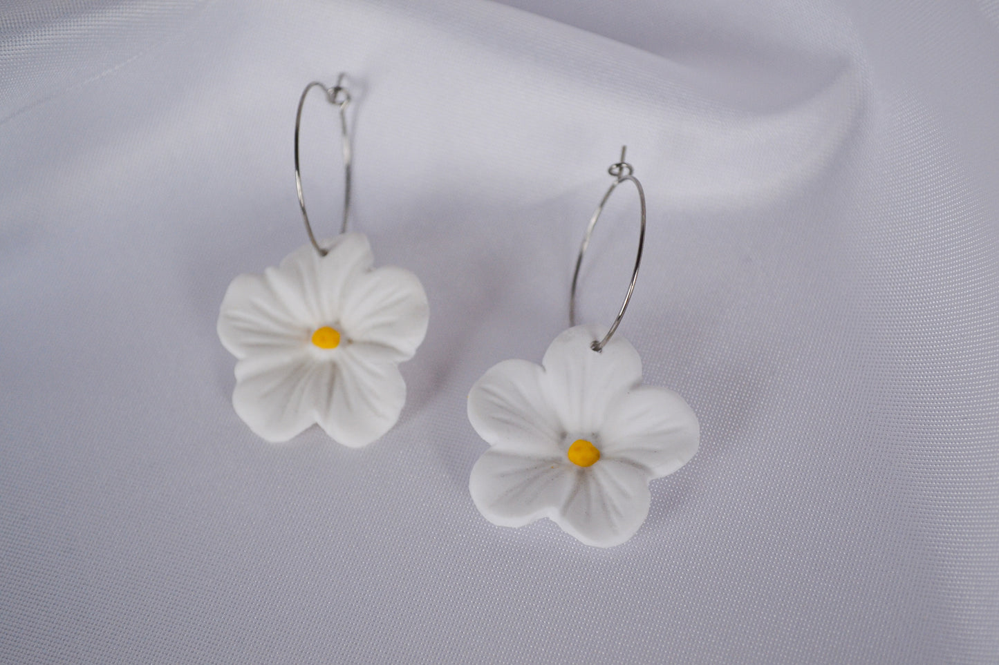 Hoop earrings with white flower pendants