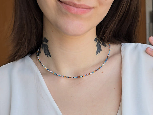 Eine Frau trägt eine bunte Glasperlenkette in Sommerfarben