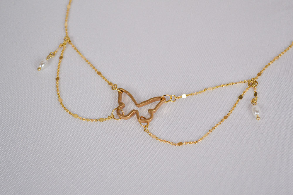 Nahaufnahme goldene Choker mit Schmetterling Verbinder und kleinen Wachsperlen
