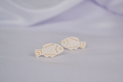 Beige Fisch Ohrstecker auf einem weißen Tuch