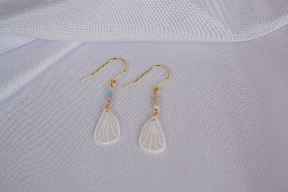 Schmertterlingsflügel an goldenen Ohrhängern mit bunten Glasperlen