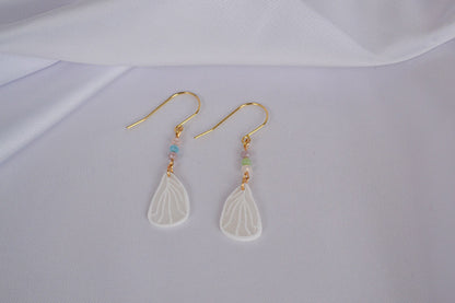 Schmertterlingsflügel an goldenen Ohrhängern mit bunten Glasperlen