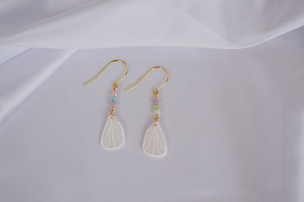 Schmertterlingsflügel an goldenen Ohrhängern mit bunten Glasperlen