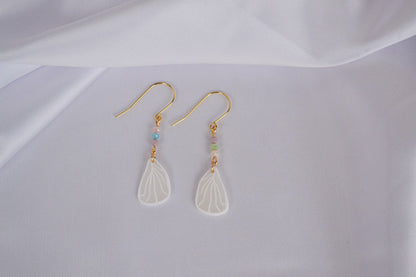 Schmertterlingsflügel an goldenen Ohrhängern mit bunten Glasperlen