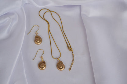Schmuckset in Gold mit Muschel Anhängern auf weißem Stoff